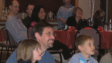 A Chicago area audience of both kids and adults smile during a family friendly comedy magic show!